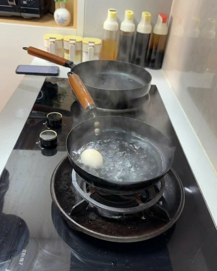 Un œuf blanc plongé dans une petite casserole deau à ébullition rapide sur une cuisinière à gaz.