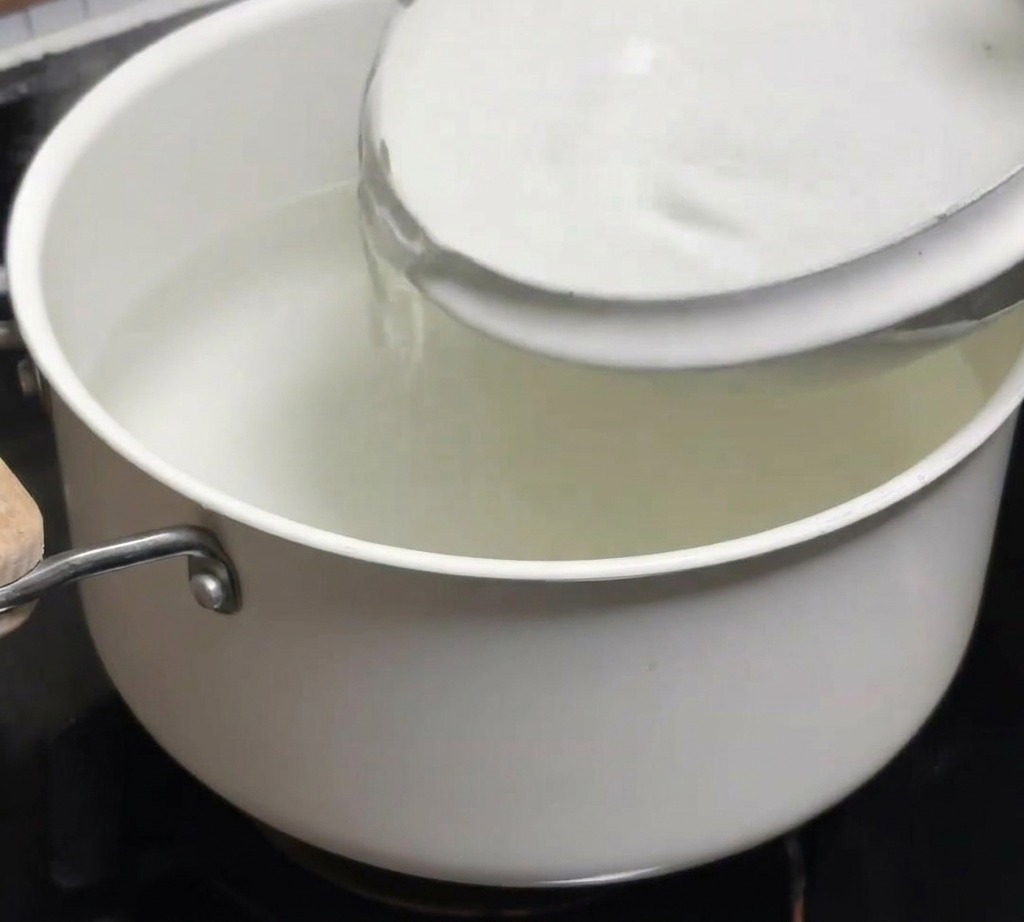 Un bol deau froide versé dans une casserole deau chaude fraîchement bouillie.