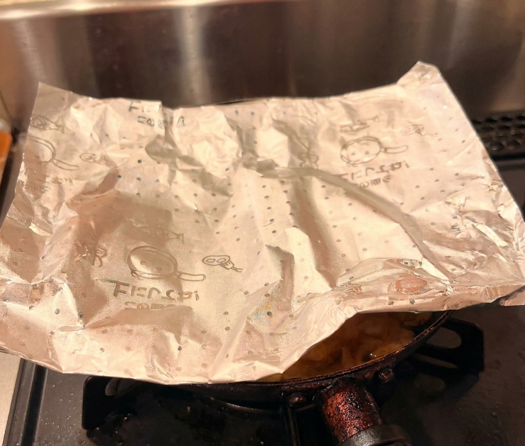 La garniture cuite de poulet et dœuf glissée délicatement depuis une poêle sur un bol de riz blanc.