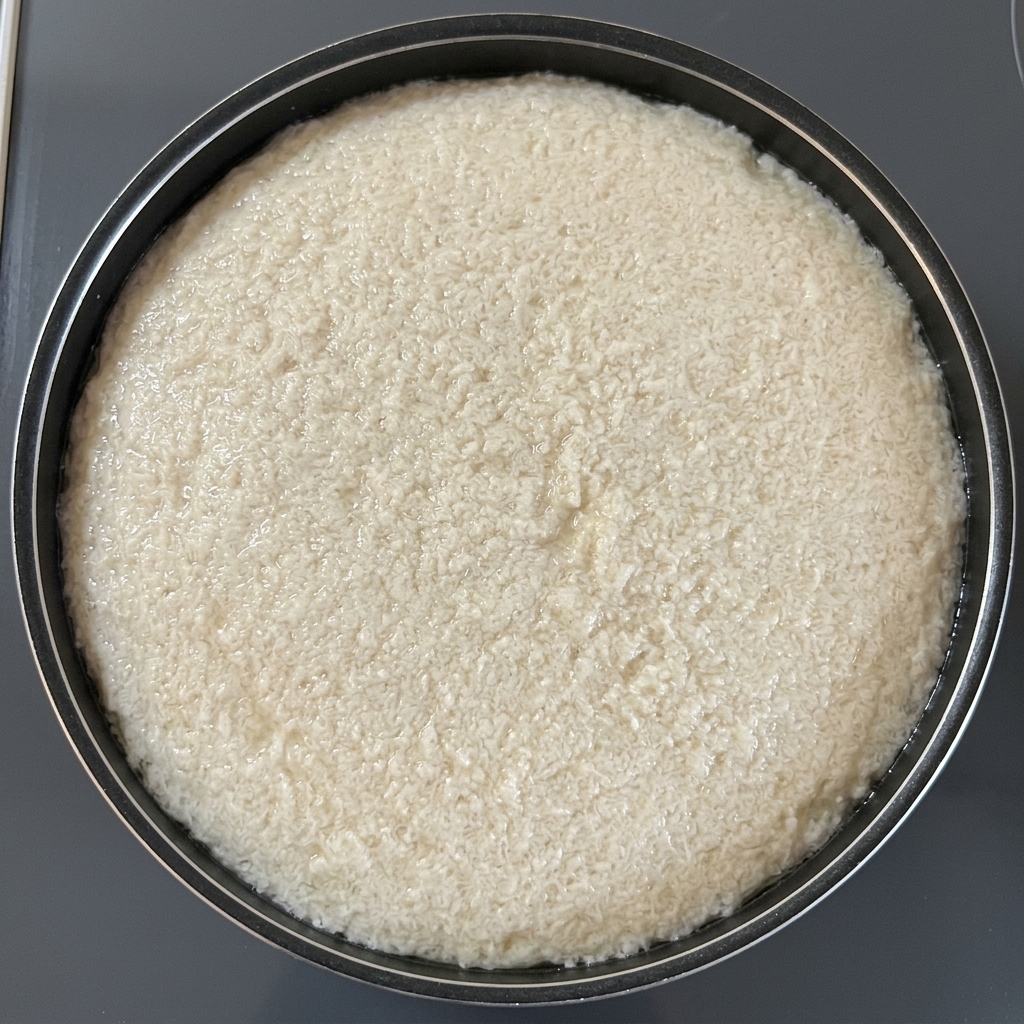 Une feuille ronde de papier absorbant flotte à la surface de leau bouillante dans une casserole noire.