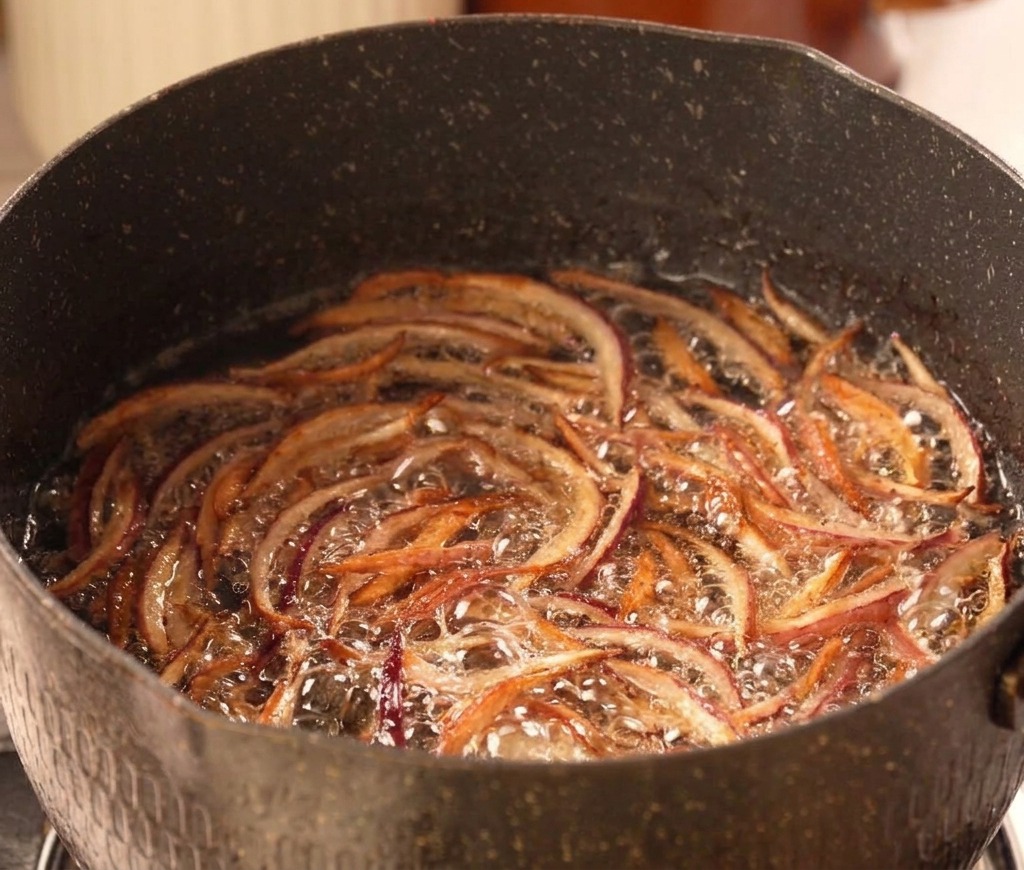 Lanières doignons rouges frémissant dans lhuile chaude, devenant dun brun doré croustillant.