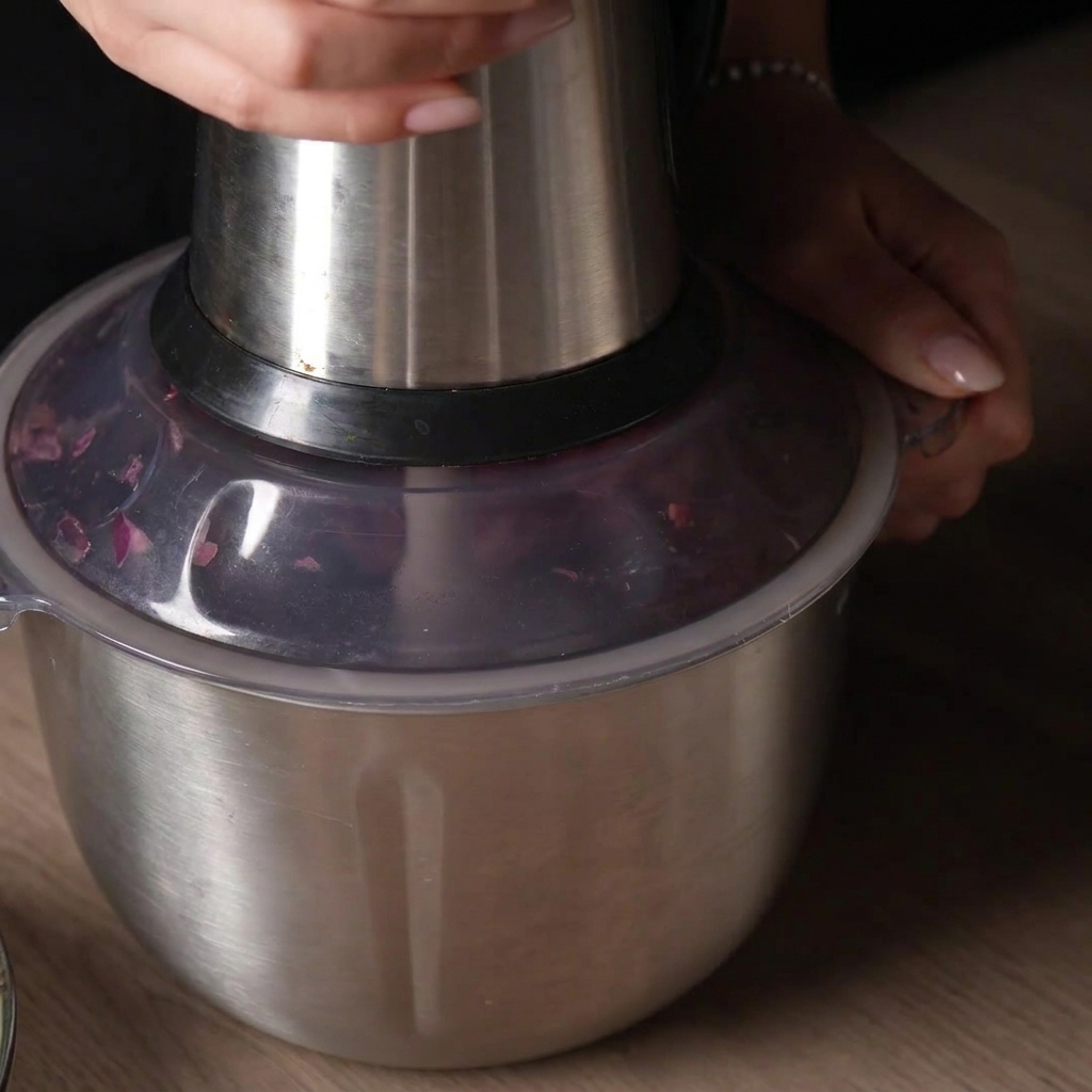 Une main pressant le couvercle dun robot culinaire pour hacher la viande par impulsions.