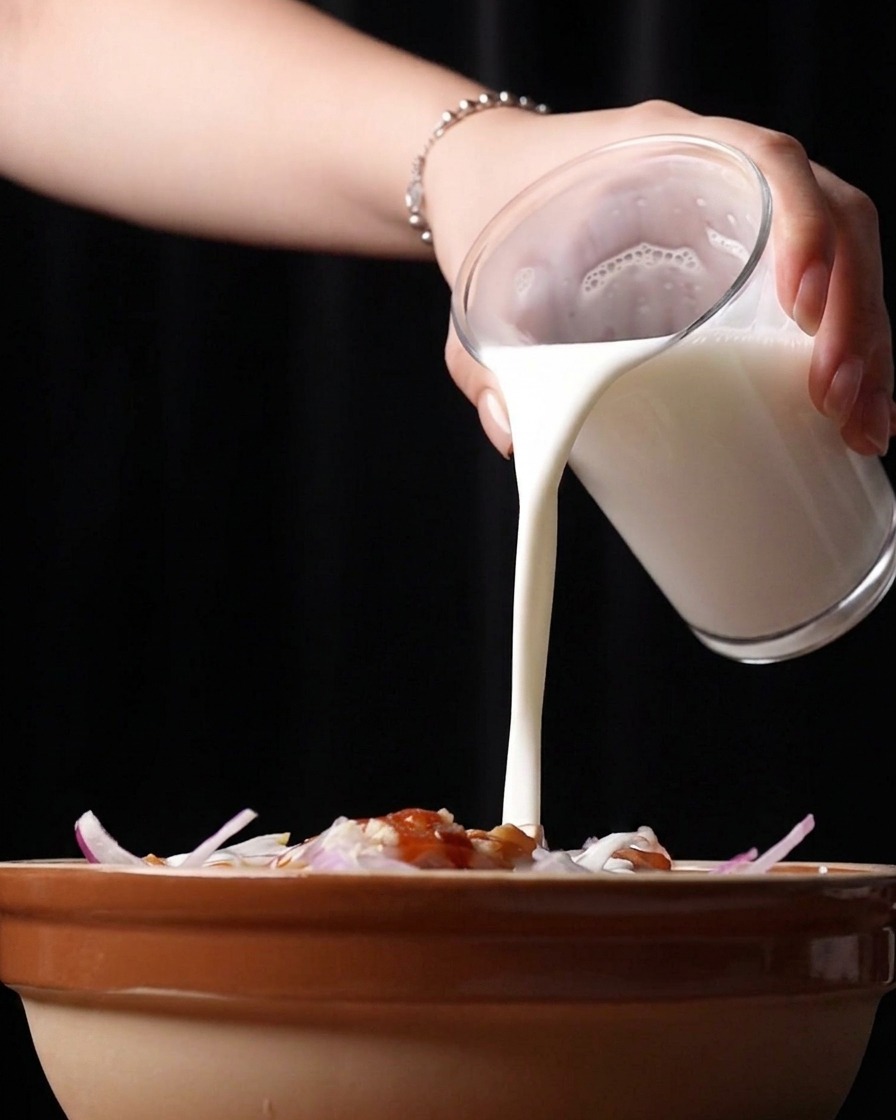 Versement de babeurre blanc et onctueux dans le bol de marinade.