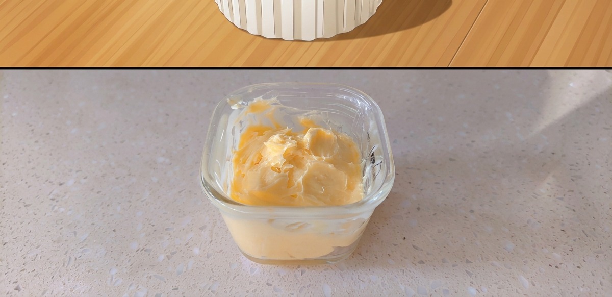 Un petit récipient en verre contenant le mélange de beurre et de moutarde jaune.