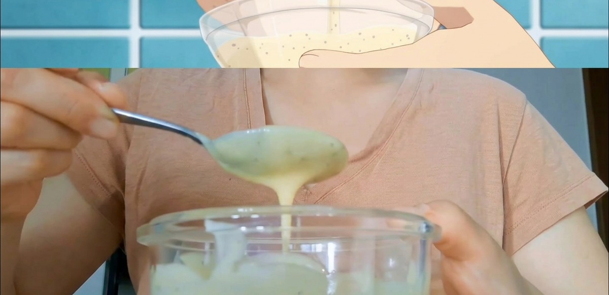 Mains mélangeant une sauce crémeuse mouchetée dans un bol en verre avec une cuillère en métal.