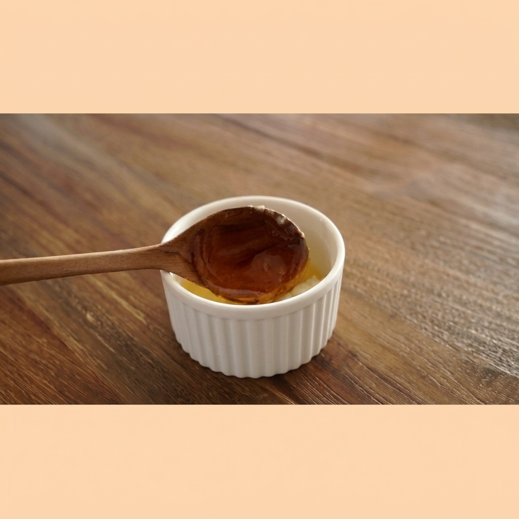 Du miel de couleur ambrée coulant dune cuillère en bois dans un bol blanc contenant le beurre à lail.