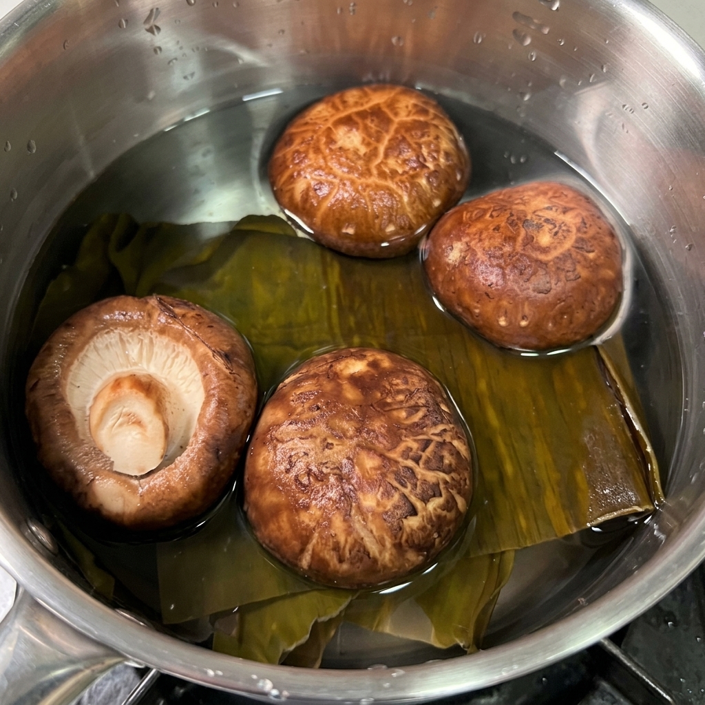 Algue kombu séchée et champignons shiitake bruns trempant dans une petite casserole deau claire.