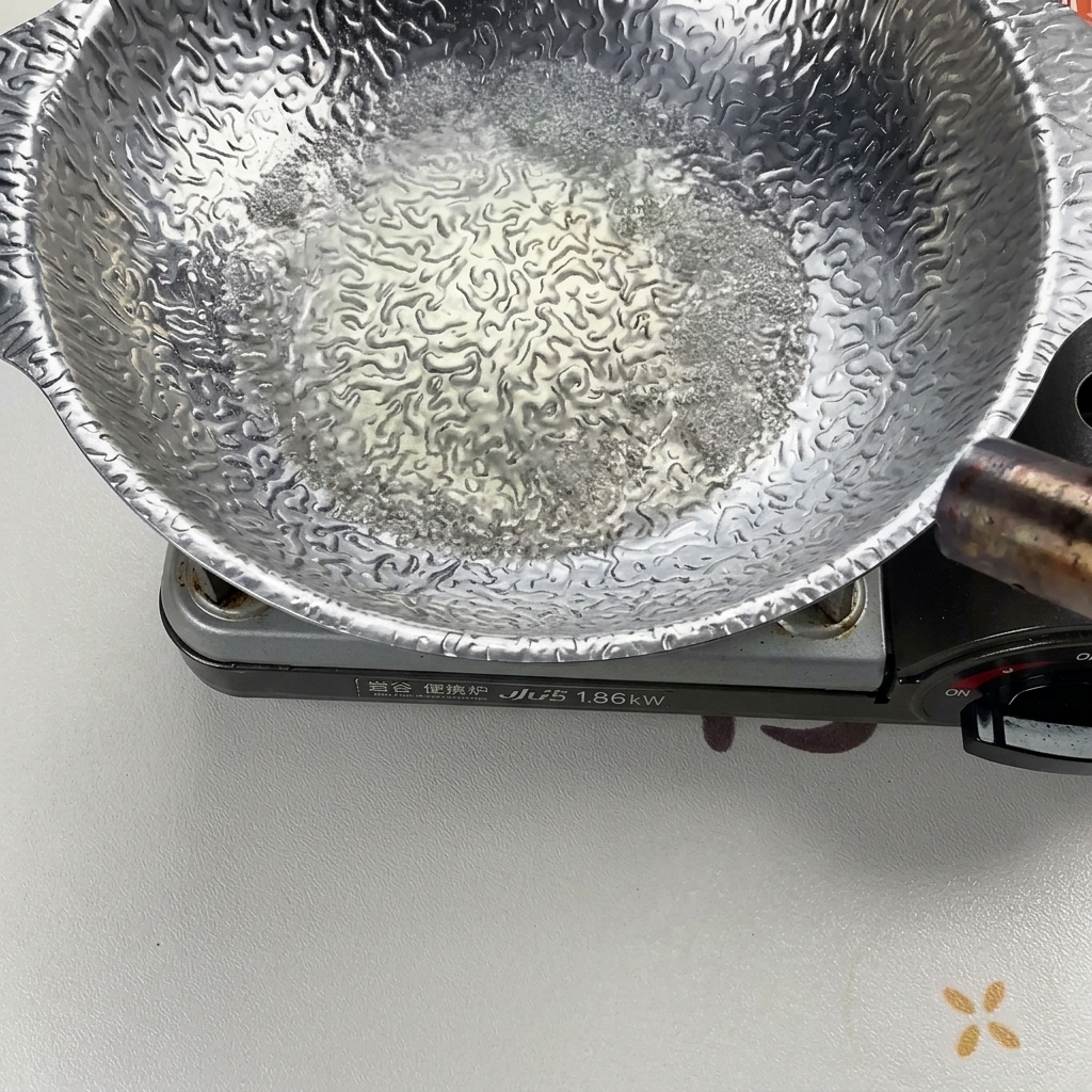 Le liquide bouillonne vigoureusement dans une casserole argentée chauffée, puis est enflammé à laide dun chalumeau pour éliminer lalcool.