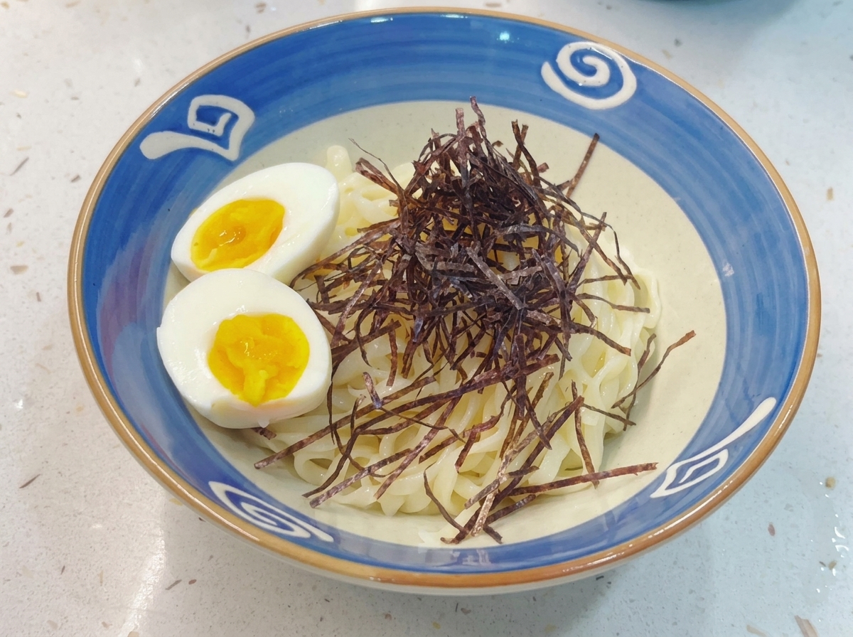 Un bol final de nouilles Tsukemen garni de nori émincé et dun œuf mollet coupé en deux.