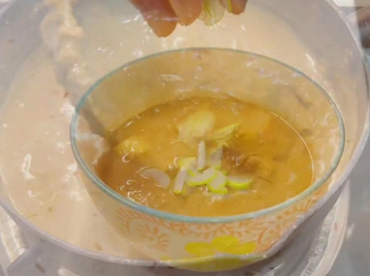Le bout des doigts parsemant des oignons verts fraîchement émincés dans un petit bol en verre rempli dun bouillon de trempette épais et savoureux.