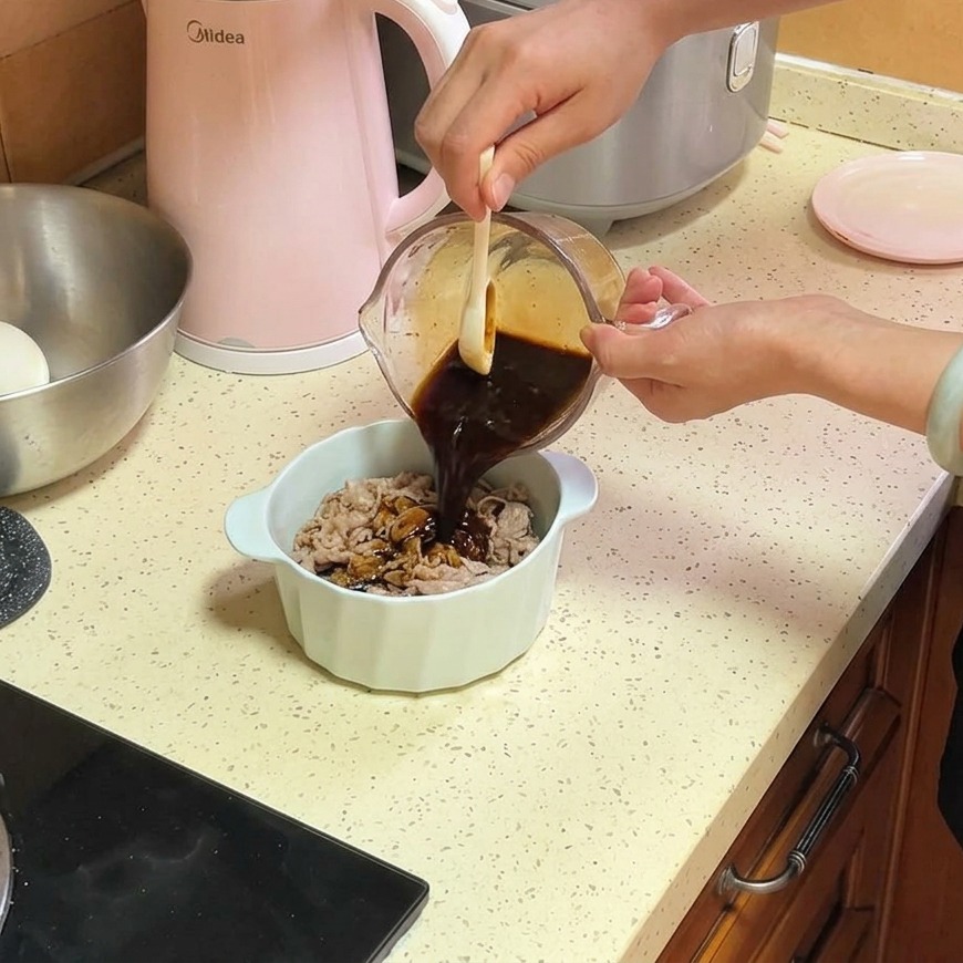 Une sauce savoureuse marron foncé versée dun verre mesureur en verre sur de fines tranches de bœuf et doignons dans un bol en céramique blanc.