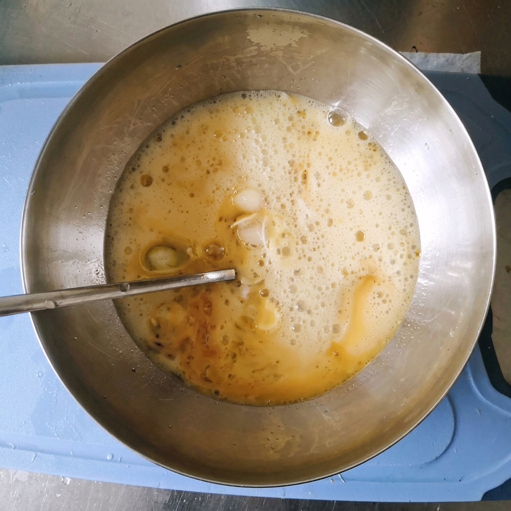 Un mélange de marinade pétillant et mousseux dans un bol en acier inoxydable après lajout deau gazeuse.