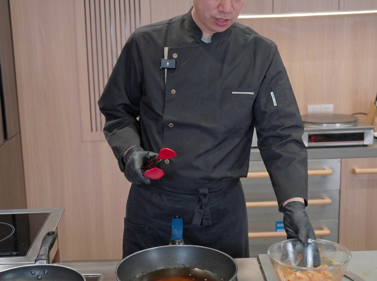Des morceaux de calamar mariné cuisant dans une grande poêle remplie dhuile chaude et bouillonnante.