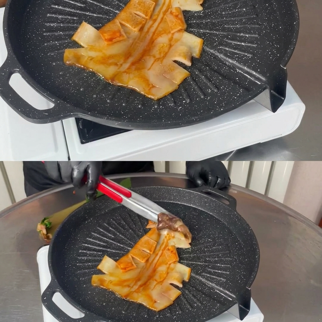 Une pince en métal déposant un calamar mariné entier à plat sur une poêle grill noire, chaude et striée.