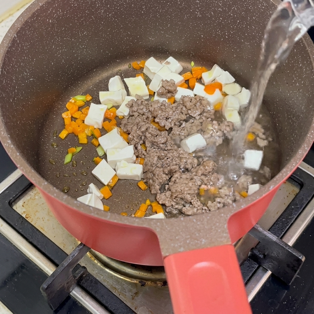 Mélange de tofu, bœuf et carottes avec de leau bouillante versée dans la casserole.