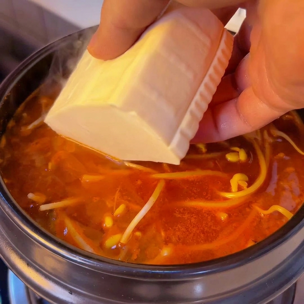 Bloc de tofu soyeux ajouté dans le pot.