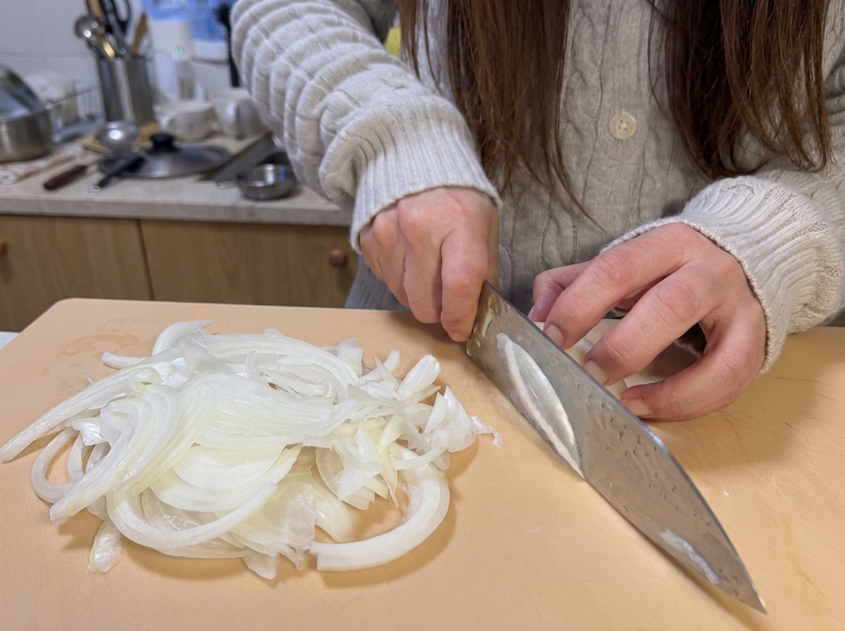 Tranches doignon finement coupées sur une planche à découper, prêtes à être cuisinées.