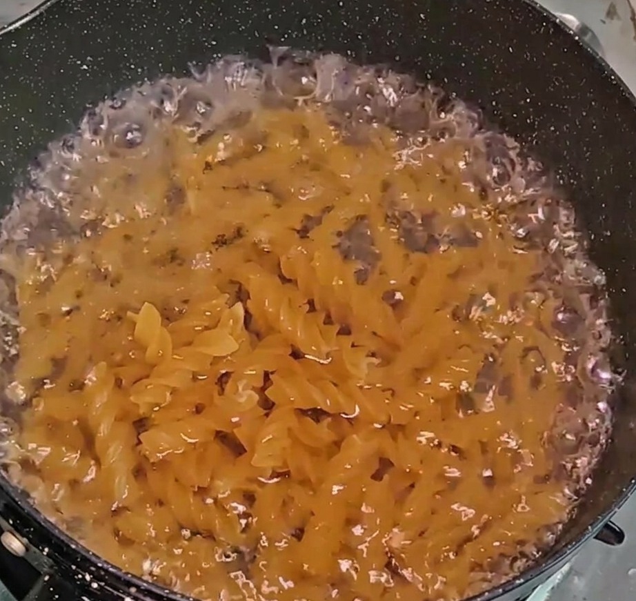 Fusillis en train de cuire dans une casserole deau frémissante.