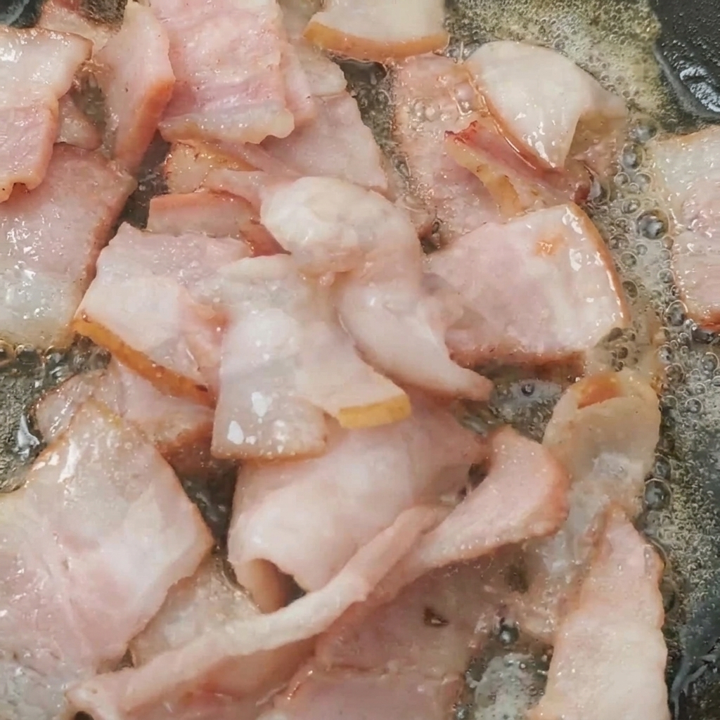 Tomates cerises cuisant avec les dés de bacon croustillants.