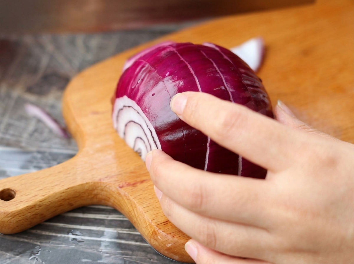 Oignon rouge coupé en petits dés sur une planche en bois.