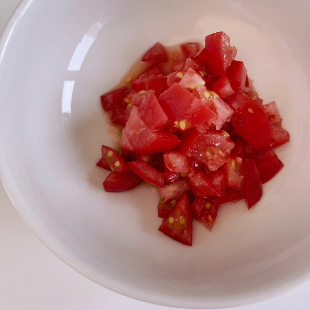 Tomates rouges fraîches coupées en petits dés sur une planche à découper en bois.