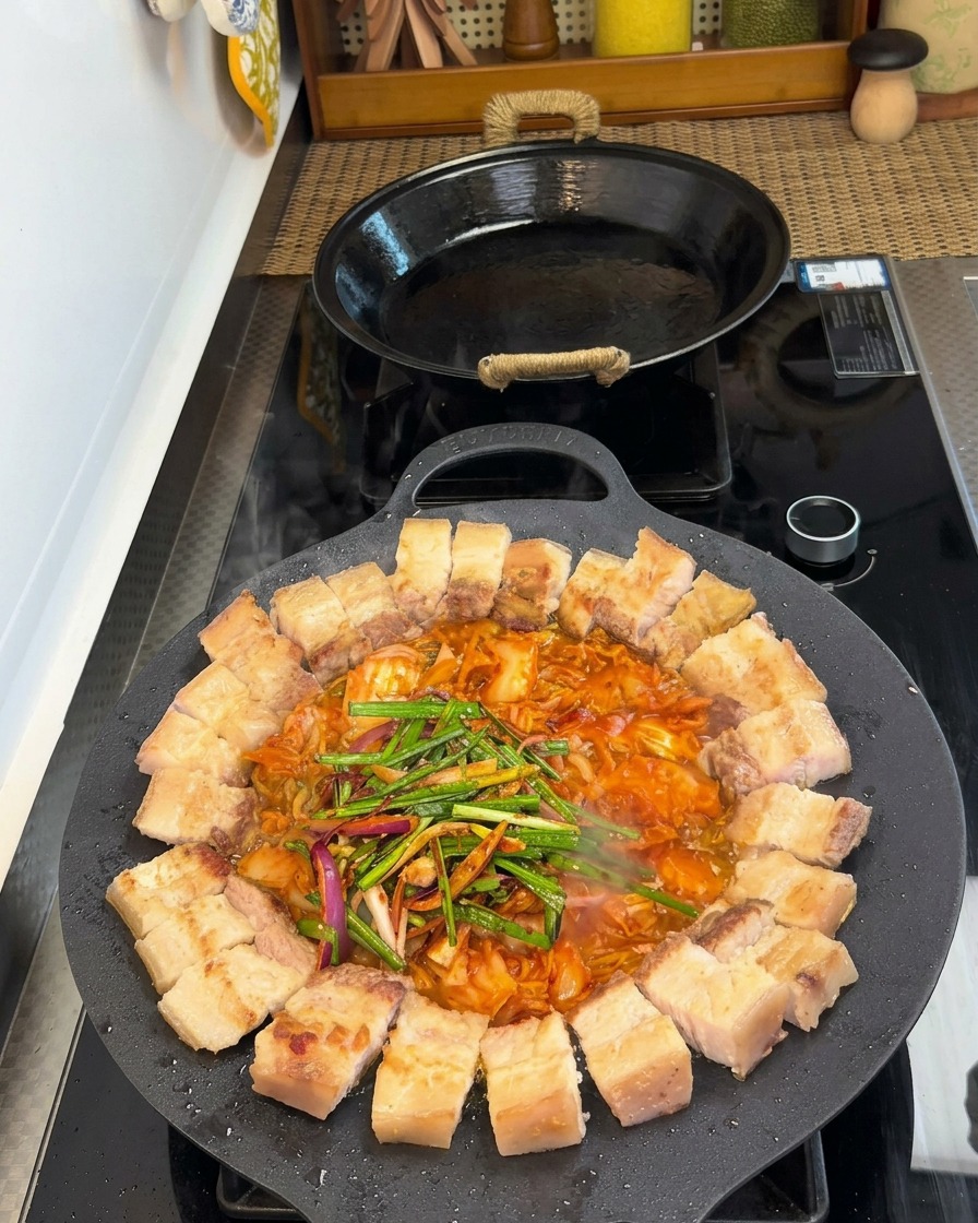 Poitrine de porc et kimchi dans la poêle, agrémentés de poireaux, oignons et épices.