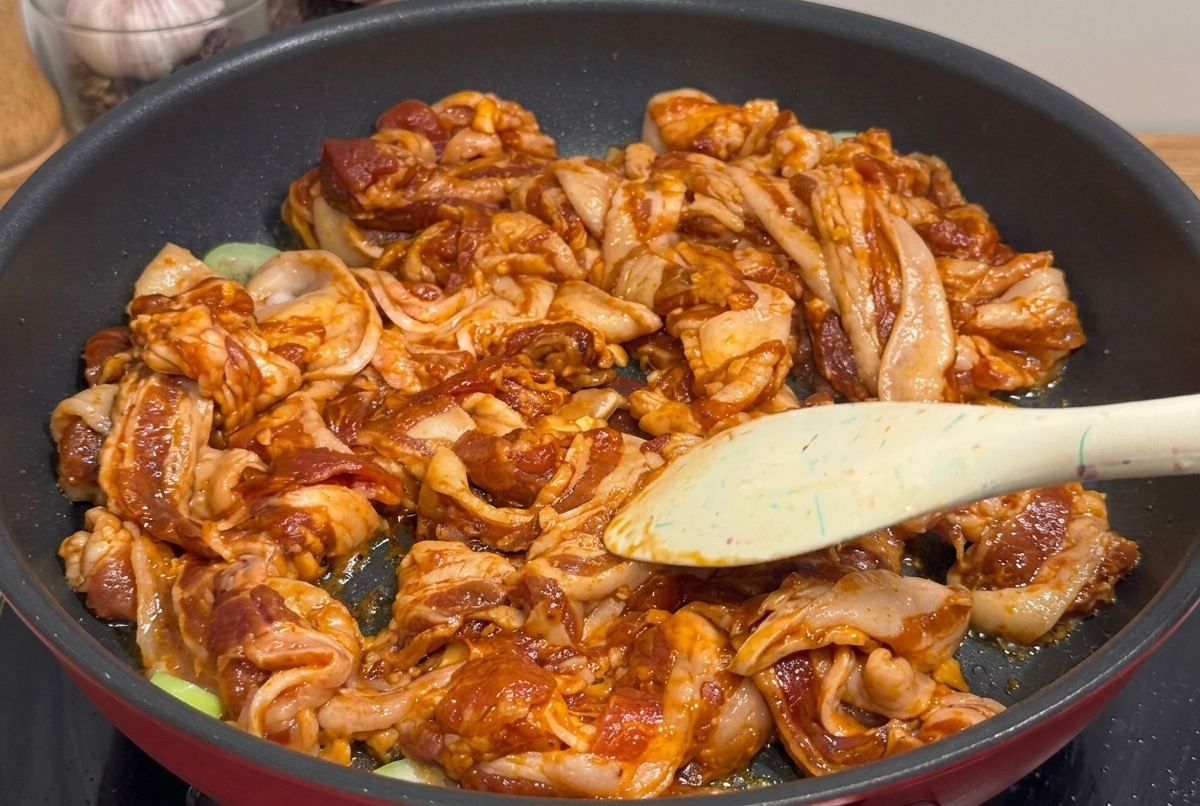 Morceaux de poitrine de porc grillée coupés aux ciseaux directement dans la poêle.