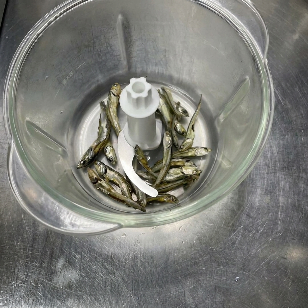 Ingrédients de poissons séchés dans un robot culinaire avant dêtre réduits en poudre.