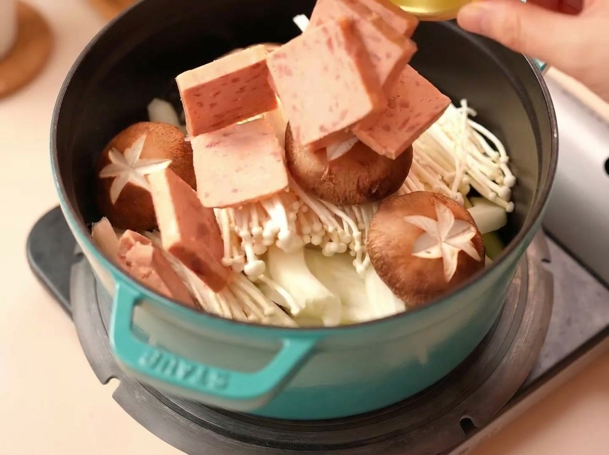 Tranches de Spam et champignons shiitake ajoutés dans la marmite.