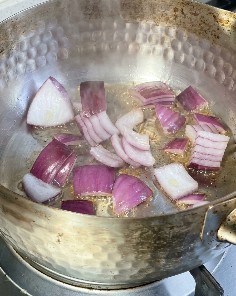 Tranches doignon rouge grésillant dans une poêle en métal avec de lhuile chaude.