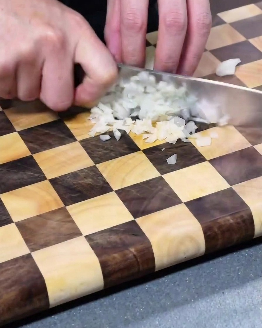 Morceaux doignon blanc finement coupés en dés, éparpillés sur une planche à découper en bois.