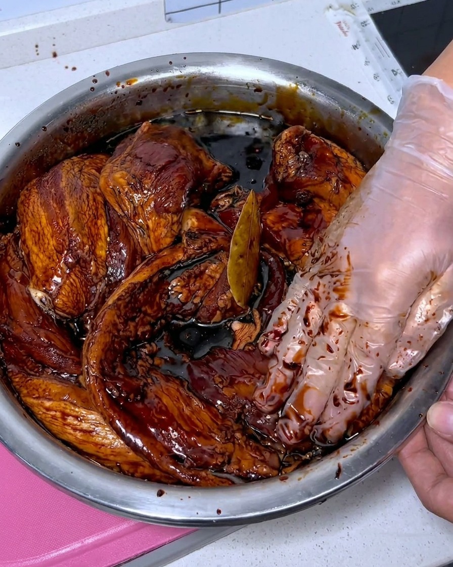 Tranches de poitrine de porc fraîche en train dêtre nettoyées avec du baijiu dans un bol en acier inoxydable.