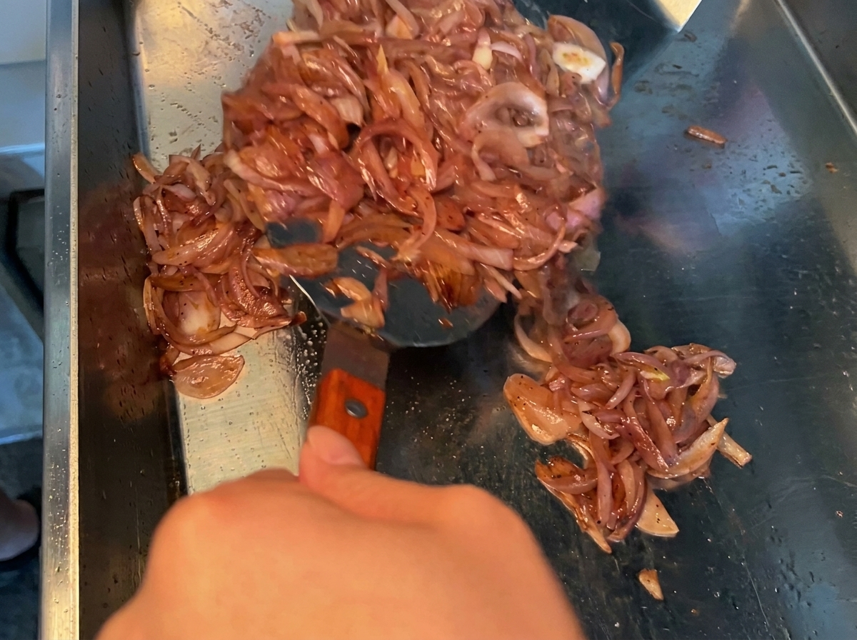 La marinade à la sauce soja versée sur des morceaux de poitrine de porc crue dans un bol en métal.