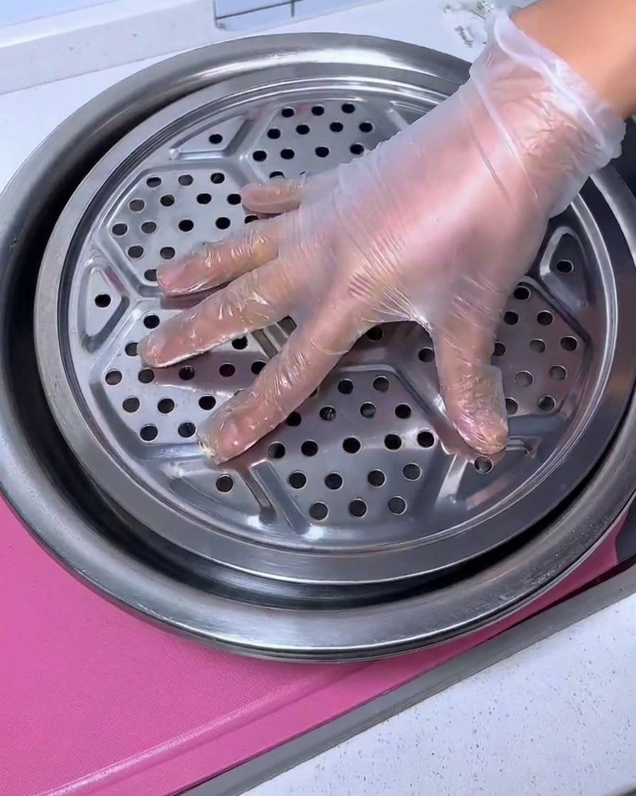 Une grille en métal utilisée comme presse pour maintenir la poitrine de porc immergée dans la marinade.