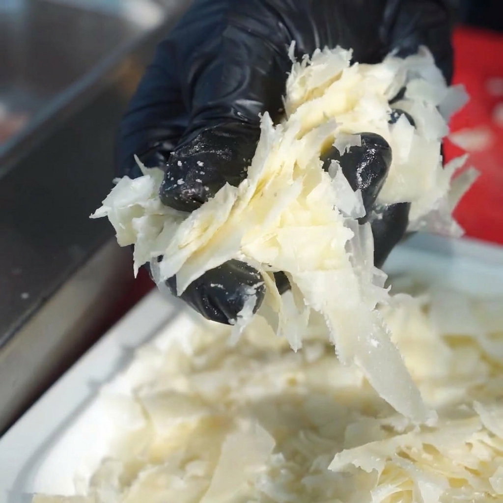 Tranches de poitrine de porc fraîche disposées dans un grand bol en inox.
