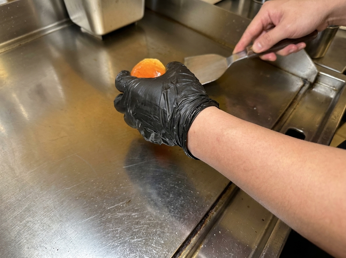 Pains à burger beurrés en train de dorer sur une plaque de cuisson bien chaude.