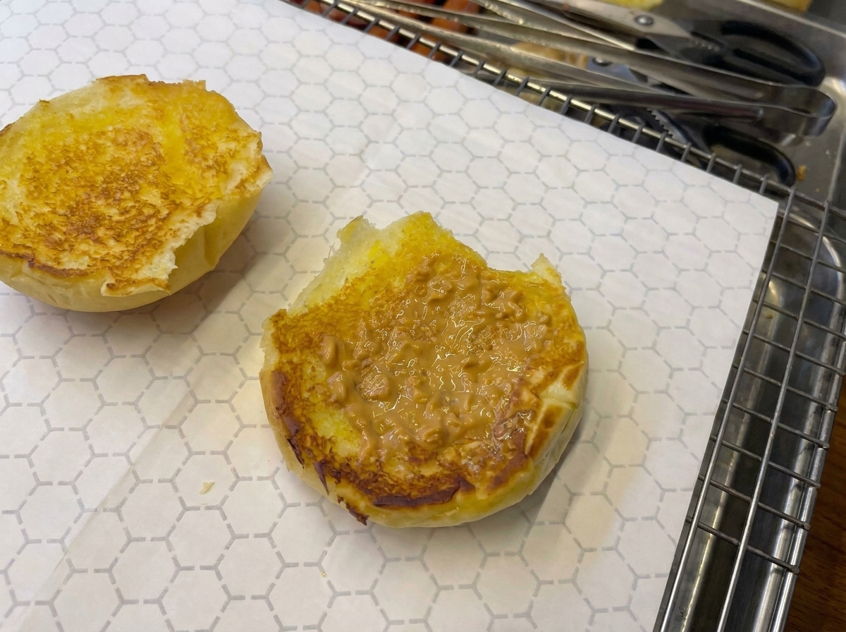 Gros plan dun pain garni de sauce et légèrement brûlé au chalumeau de cuisine.