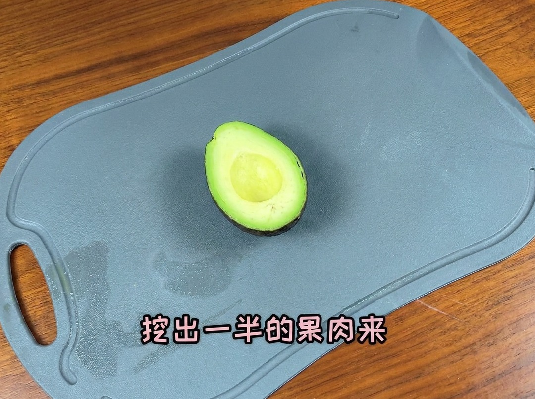 Un avocat coupé en deux sur une planche, prêt à être tranché.