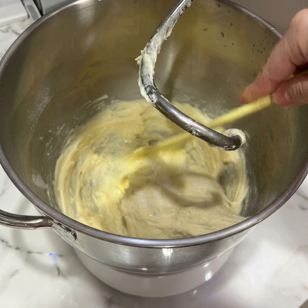Un morceau de beurre ramolli ajouté à une pâte en cours de pétrissage.