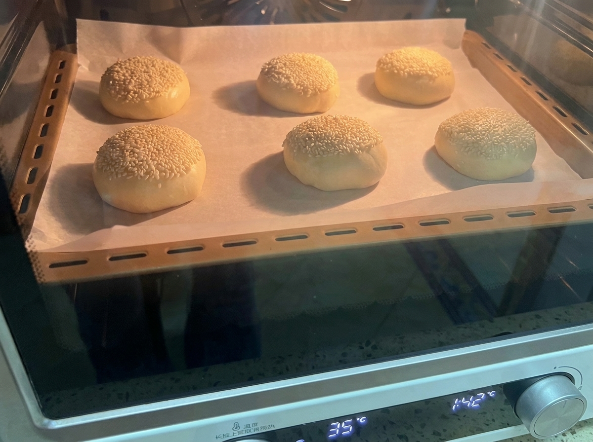 Un plateau de boules de pâte aux sésames dans un four.