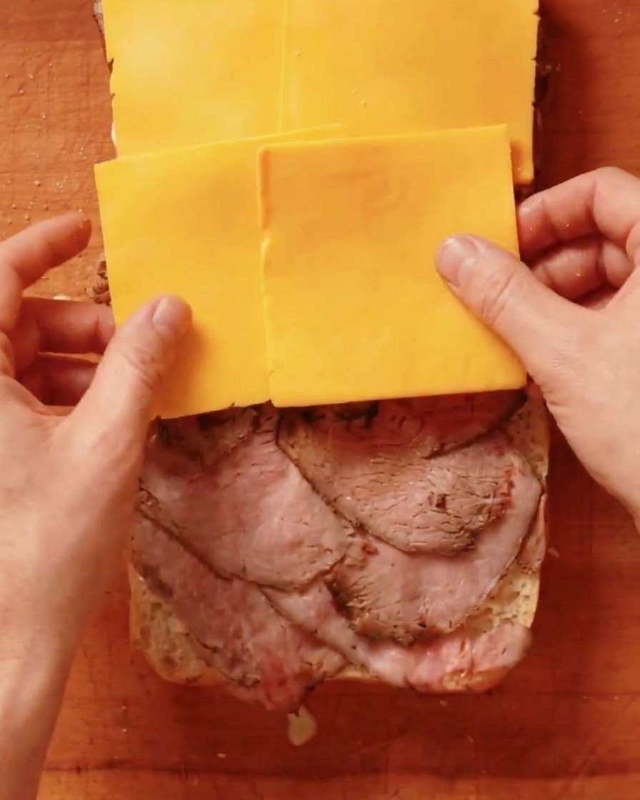 Tranches de cheddar jaune placées sur une couche de roast beef.