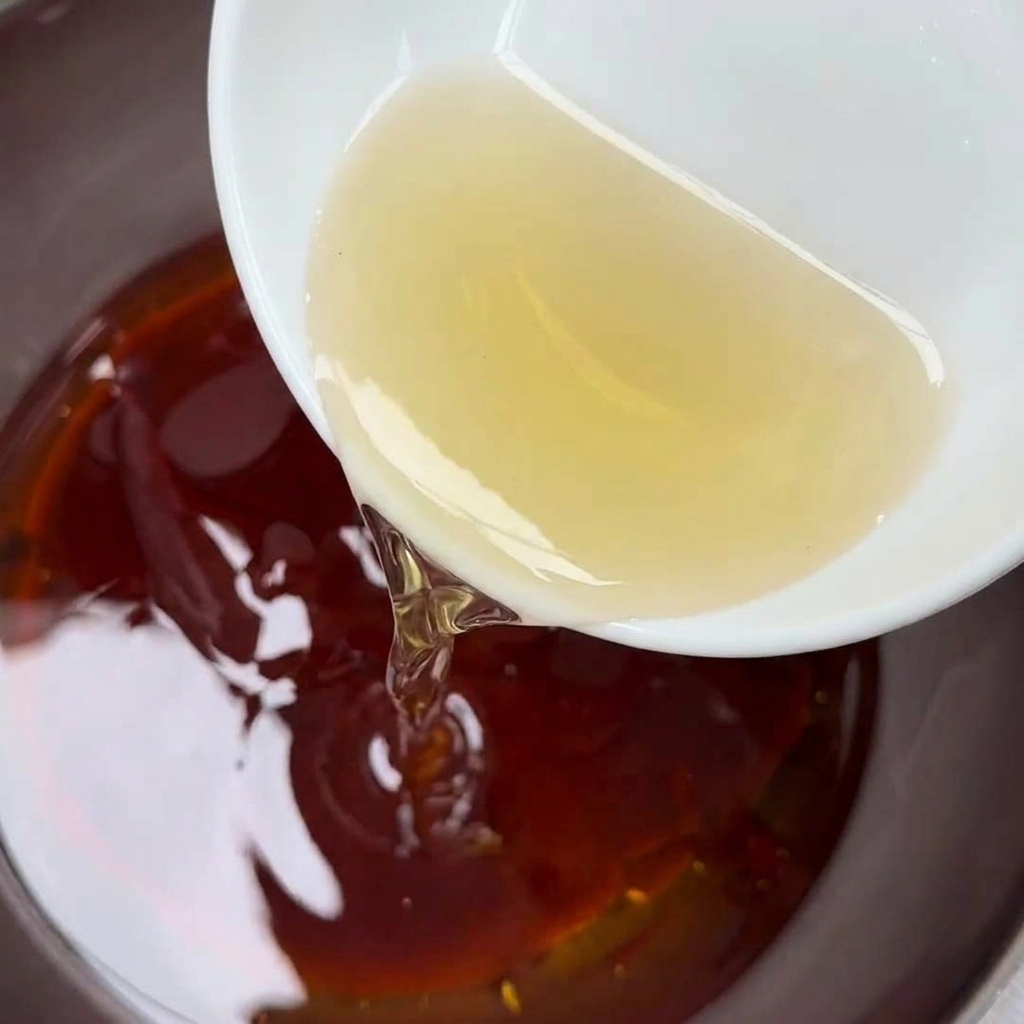 Du vinaigre de riz versé dans le bol de sauce.