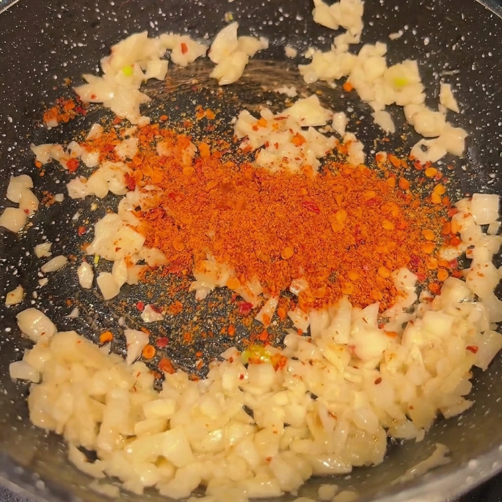 Ail haché et piment sautés dans une poêle chaude.