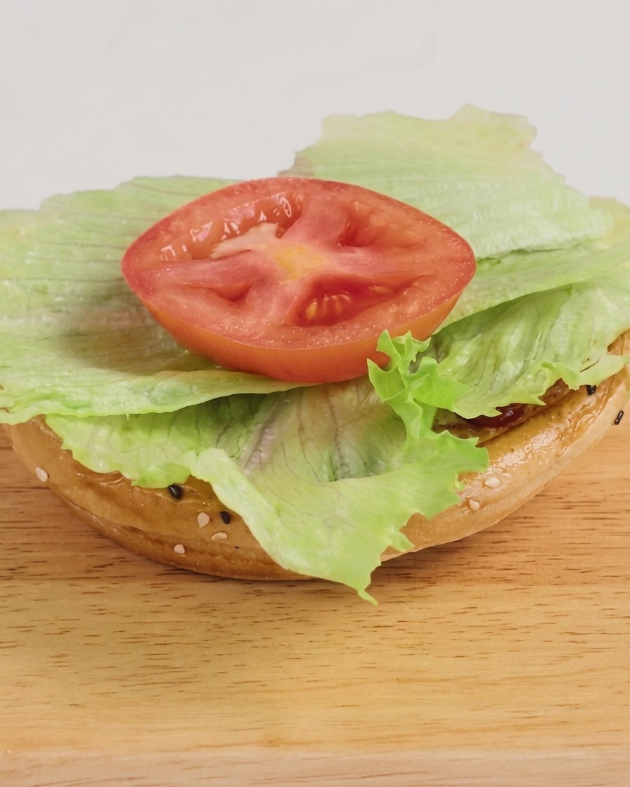 Un burger fraîchement monté avec de la laitue, un steak au fromage et un filet de sauce BBQ, prêt à être dégusté.
