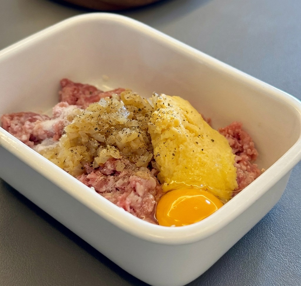 Ingrédients pour les steaks hachés japonais rassemblés dans un récipient blanc.