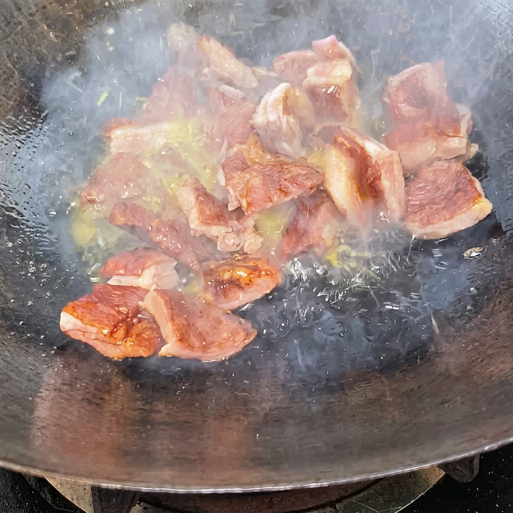 Morceaux de travers sautés dans un wok enrobés dun glaçage caramel foncé.