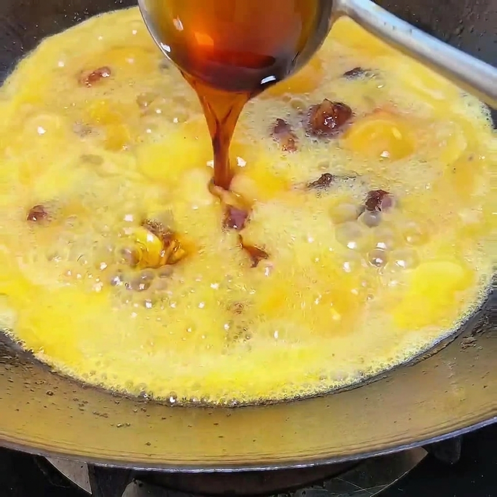 Sauce soja versée dans un wok frémissant rempli de travers, de piments et de bouillon aromatique.