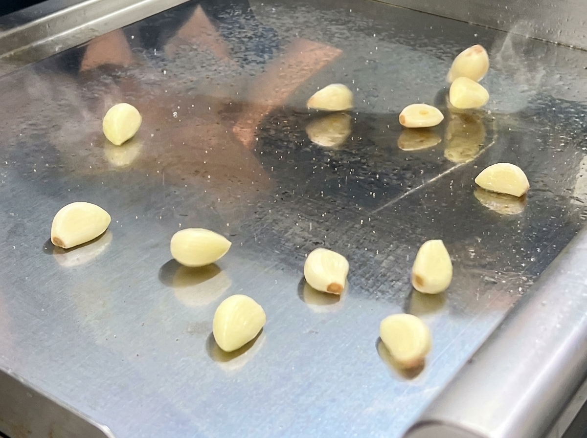 Le mélange de piments et aromates sautés étant transféré dans un robot culinaire.