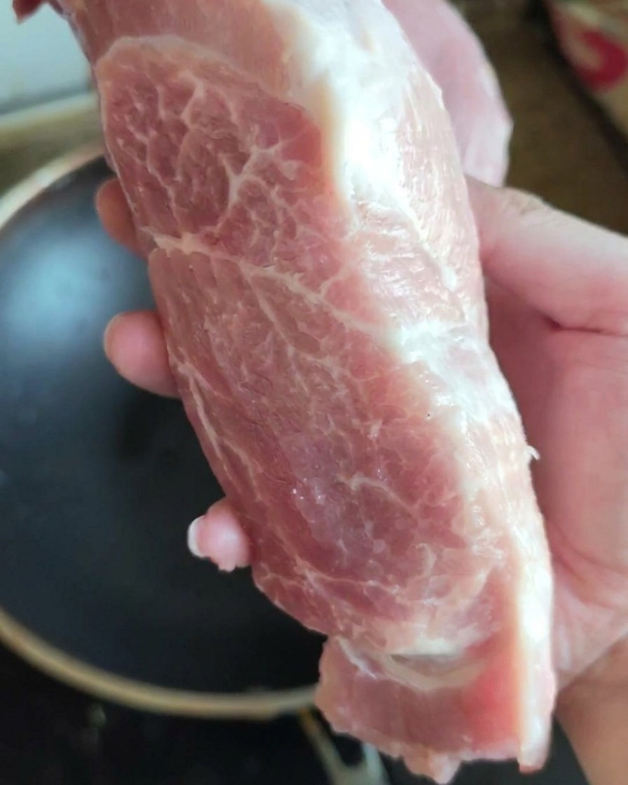 Un beau morceau dépaule de porc crue présenté devant lobjectif.
