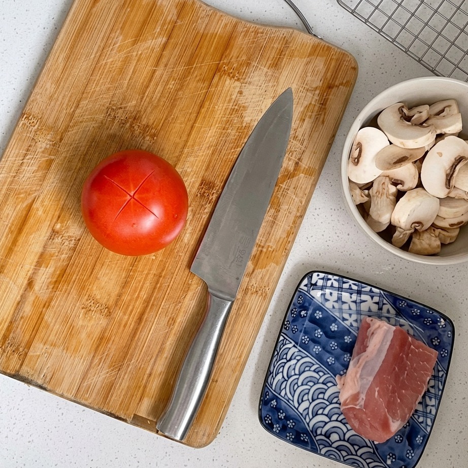 Gros plan sur une tomate rouge avec une croix incisée sur le dessus.
